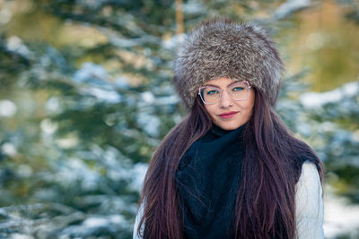 Portrait of a woman in eyeglasses and white clothes in a cold winter forest