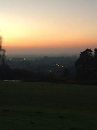 Scenic view of field against sky at sunset