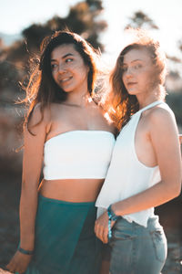 Portrait of smiling young women standing against sky
