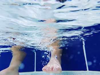 Low section of boy swimming in pool