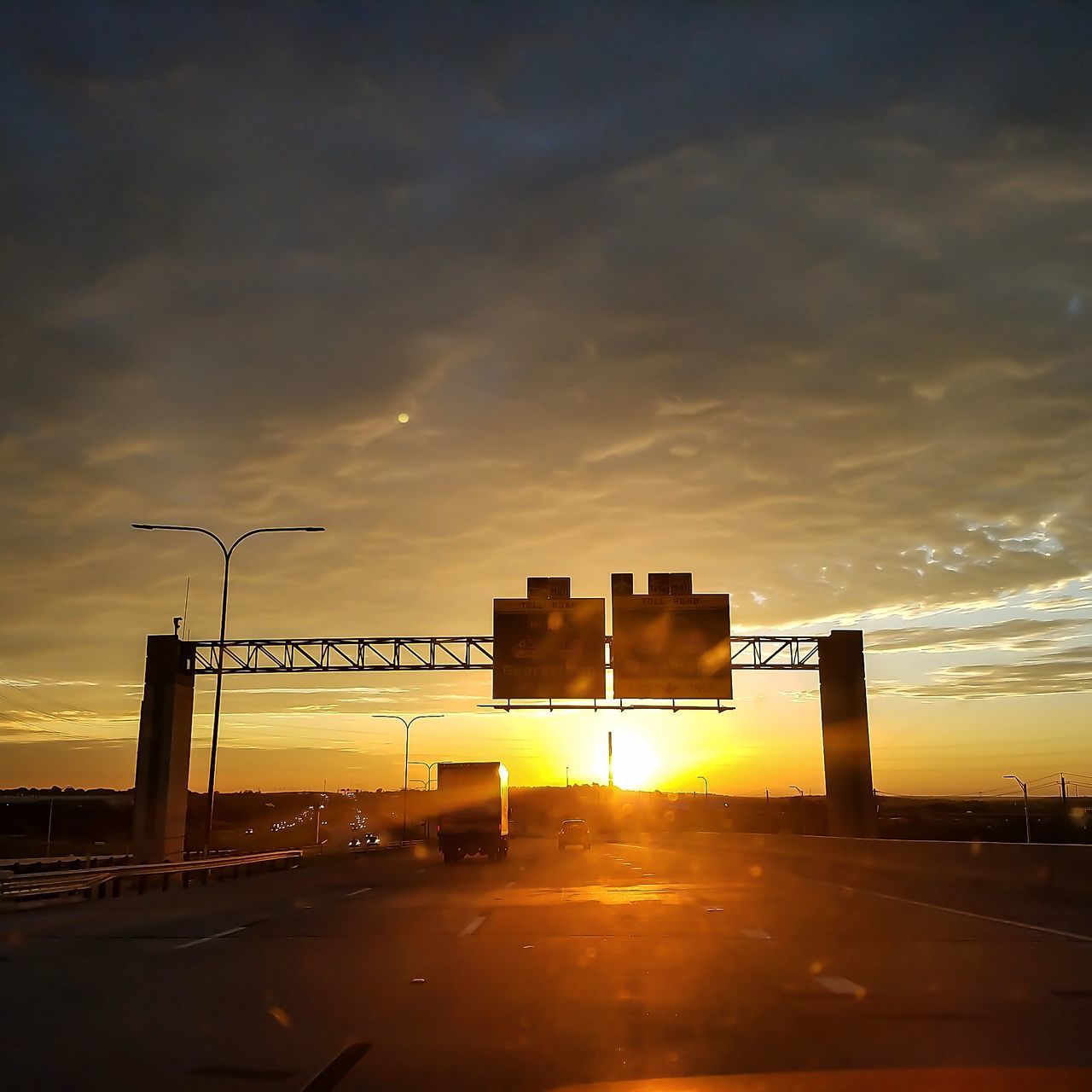 sunset, architecture, building exterior, built structure, street, road, sun, sunlight, sunbeam, cloud, sky, orange color, cloud - sky, outdoors, dark, lens flare, dramatic sky, bright