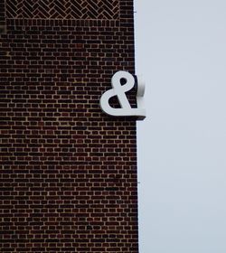 Low angle view of sign on building against clear sky