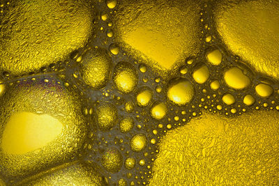 Abstract background of yellow oil drops on water