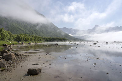 Scenic view of lake and mountains against sky