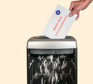 Close-up of hand holding paper over white background