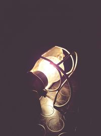 Close-up of illuminated lighting equipment against black background