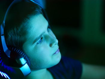 Close-up of boy wearing headphones sitting at home