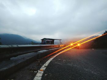 Car on road against cloudy sky