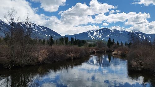 Scenic view of lake by mountains against sky