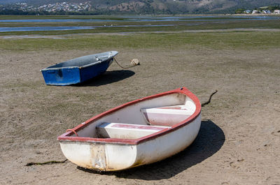 Abandoned boat moored on shore