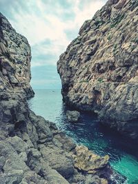 Rock formations by sea against sky