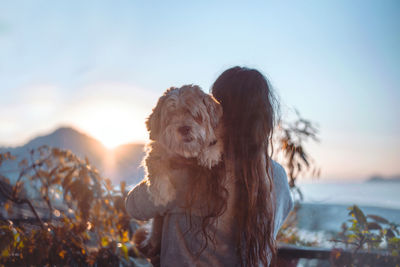 Portrait of small dog on land against sky