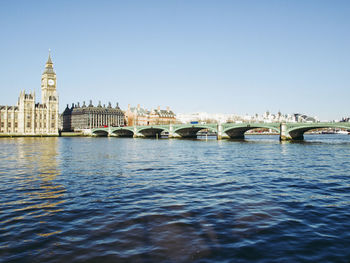 Arch bridge over river against sky in city