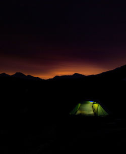 Scenic view of silhouette mountains against sky at night