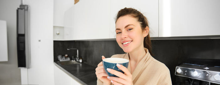 Young woman drinking coffee at home