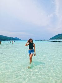 Full length of woman on beach against sky