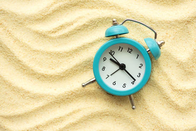 High angle view of clock on sand