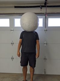 Rear view of boy standing against wall