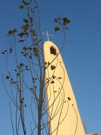 Low angle view of trees against clear blue sky