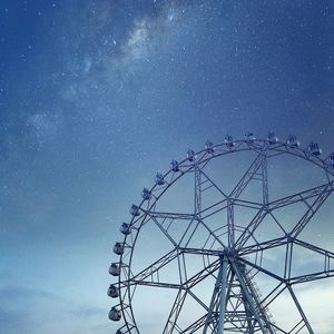 Low angle view of ferris wheel against sky at dusk