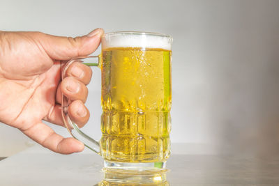 Close-up of hand holding beer glass