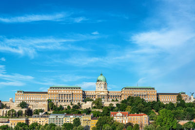 Buildings in city against blue sky