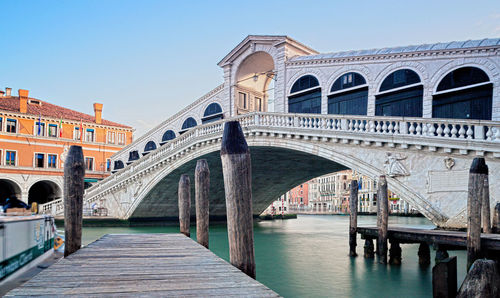 Arch bridge over river against blue sky