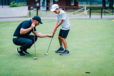 Full length of men playing on golf course