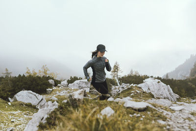 Young woman running on field during foggy weather