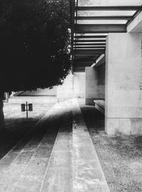 Empty footpath amidst buildings in city