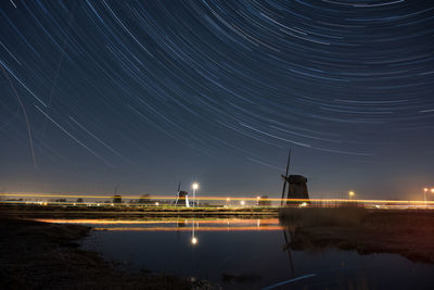 Scenic view of stream against star trail at night