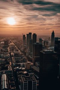 Aerial view of buildings in city against sky during sunset