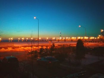 Illuminated street lights against clear sky at night