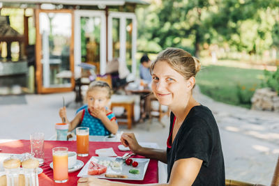 Portrait of smiling woman sitting at restaurant table