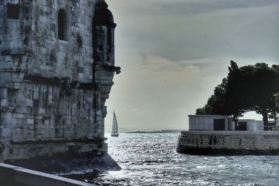 Buildings by sea against sky