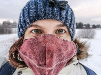 Portrait of woman covered with snow in a mask