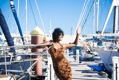 Woman with sailboat in sea against clear sky