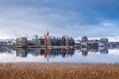 Reflection of buildings in lake against sky