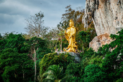 Statue amidst trees against sky