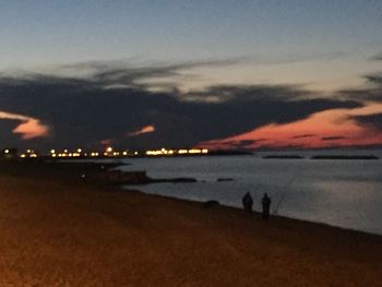 Scenic view of beach against sky at sunset