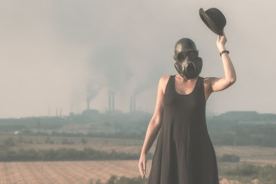 Woman wearing gas mask against sky