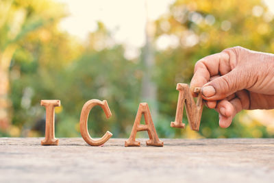 Cropped hand holding wooden letter over table