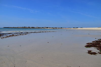 Scenic view of beach against blue sky