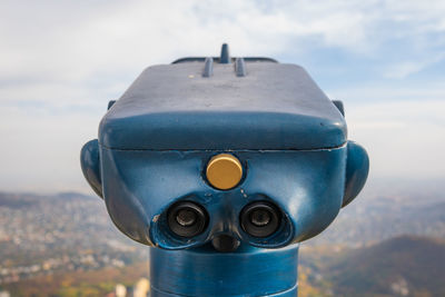 Close-up of coin-operated binoculars against sky