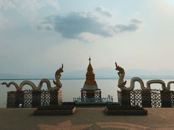 Sculpture of building against cloudy sky