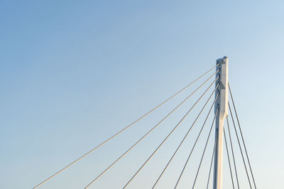 Low angle view of suspension bridge against clear blue sky