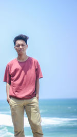 Portrait of young man standing at beach