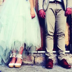 Low section of wedding couple standing against wall