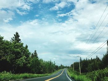 Road amidst trees against sky