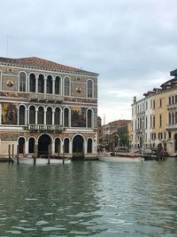 Arch bridge over river against buildings